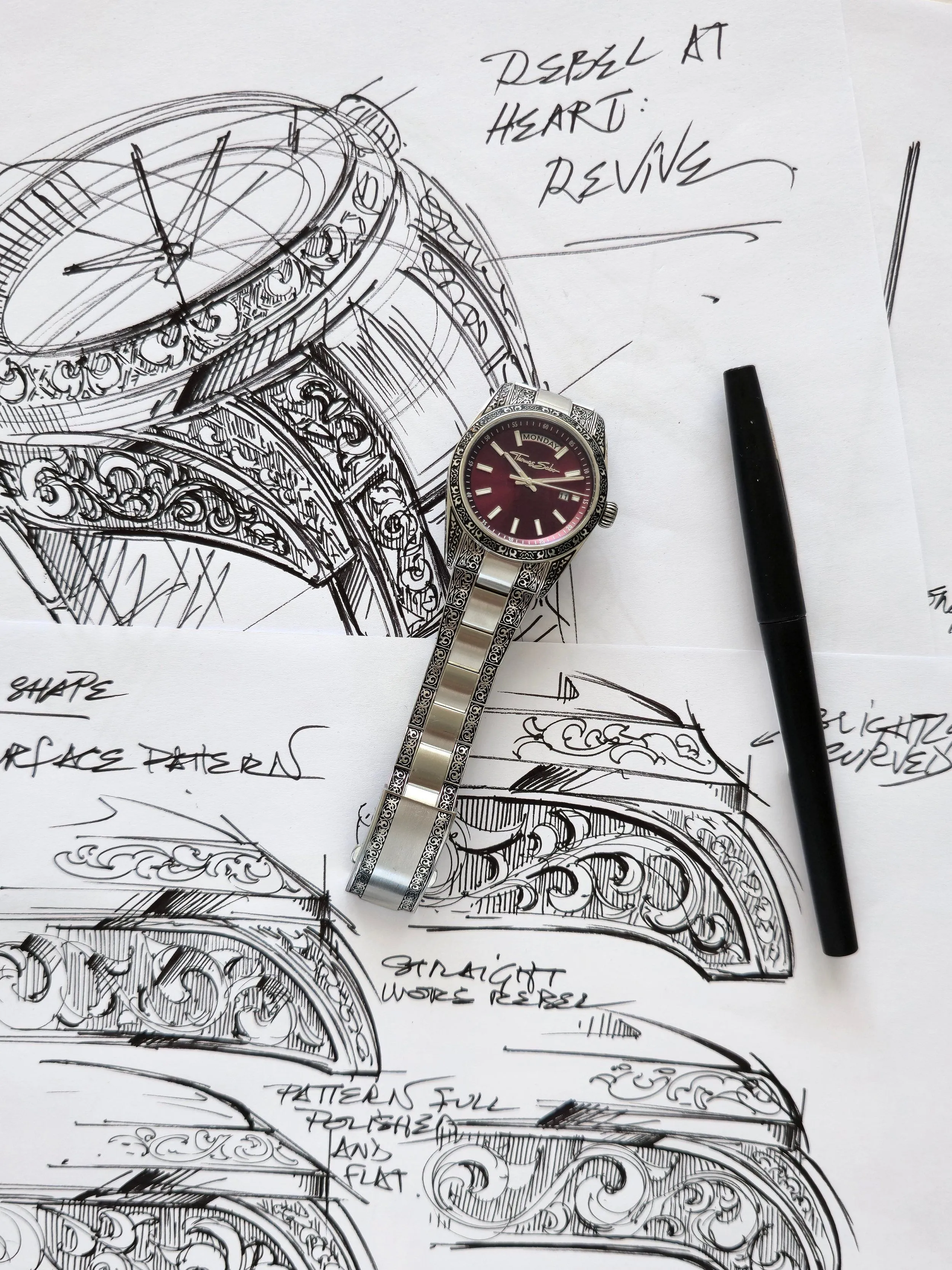 Watch sketches with the finished engraved watch laid on top, from drawing to real watch, ACTE.5
