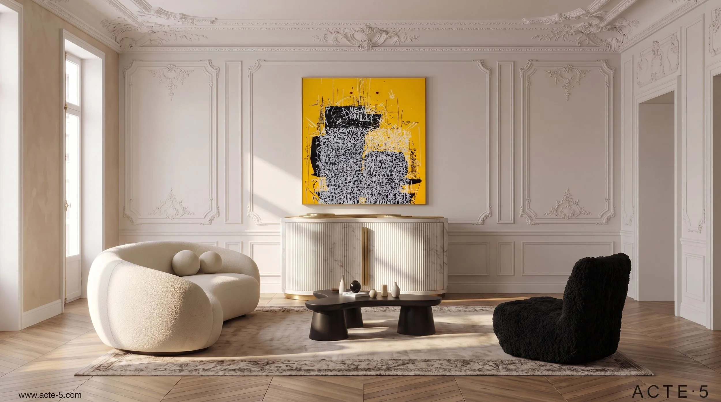 A contemporary living room with white ornate wall moldings, a large yellow and black abstract painting, a white curved sofa with neutral pillows, and a black armchair. A striped marble-top console table with small decorative objects stands against the wall.