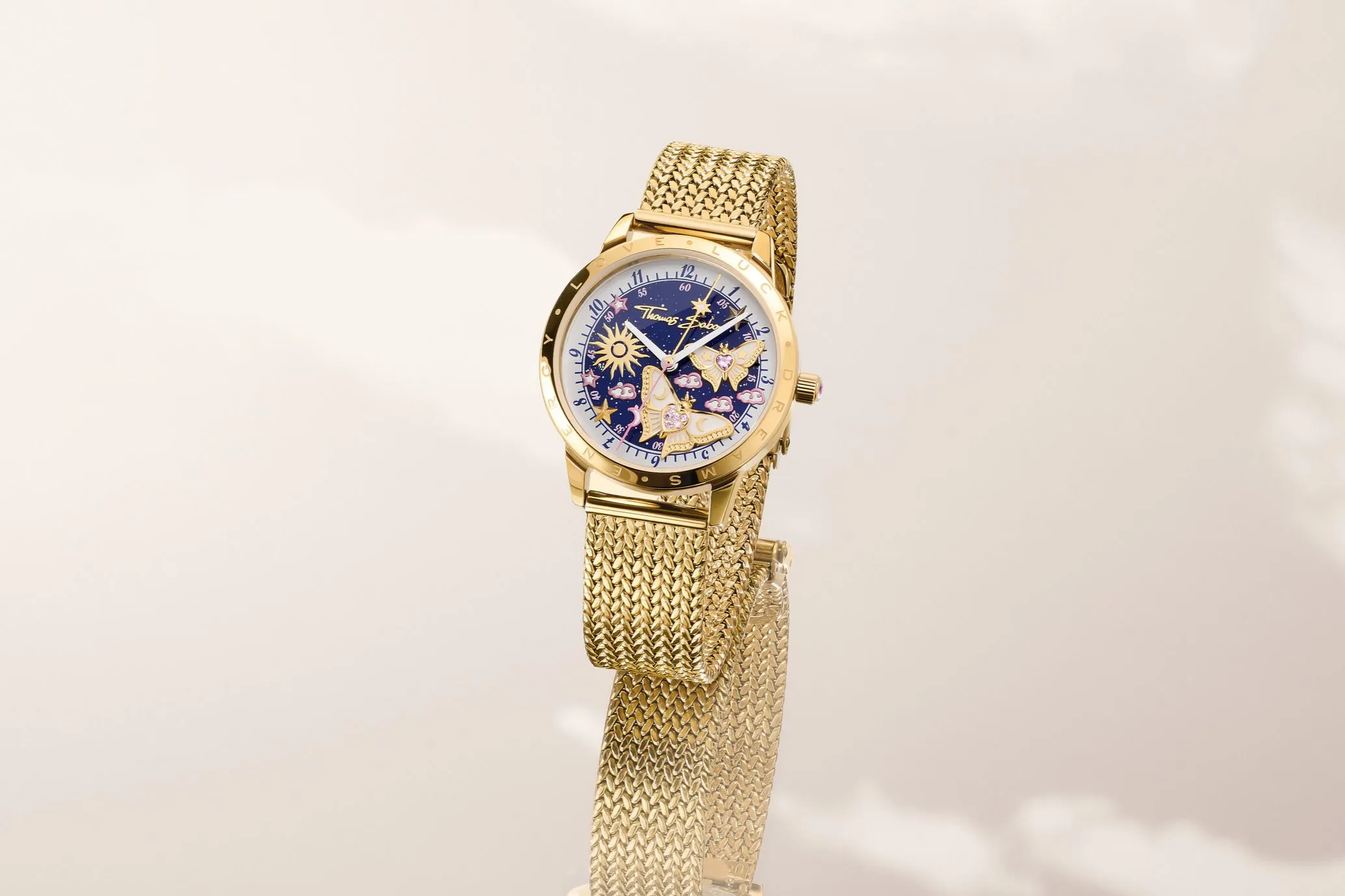 Blooming Sky watch, gold case with a celestial blue dial featuring stars, clouds and a sunburst